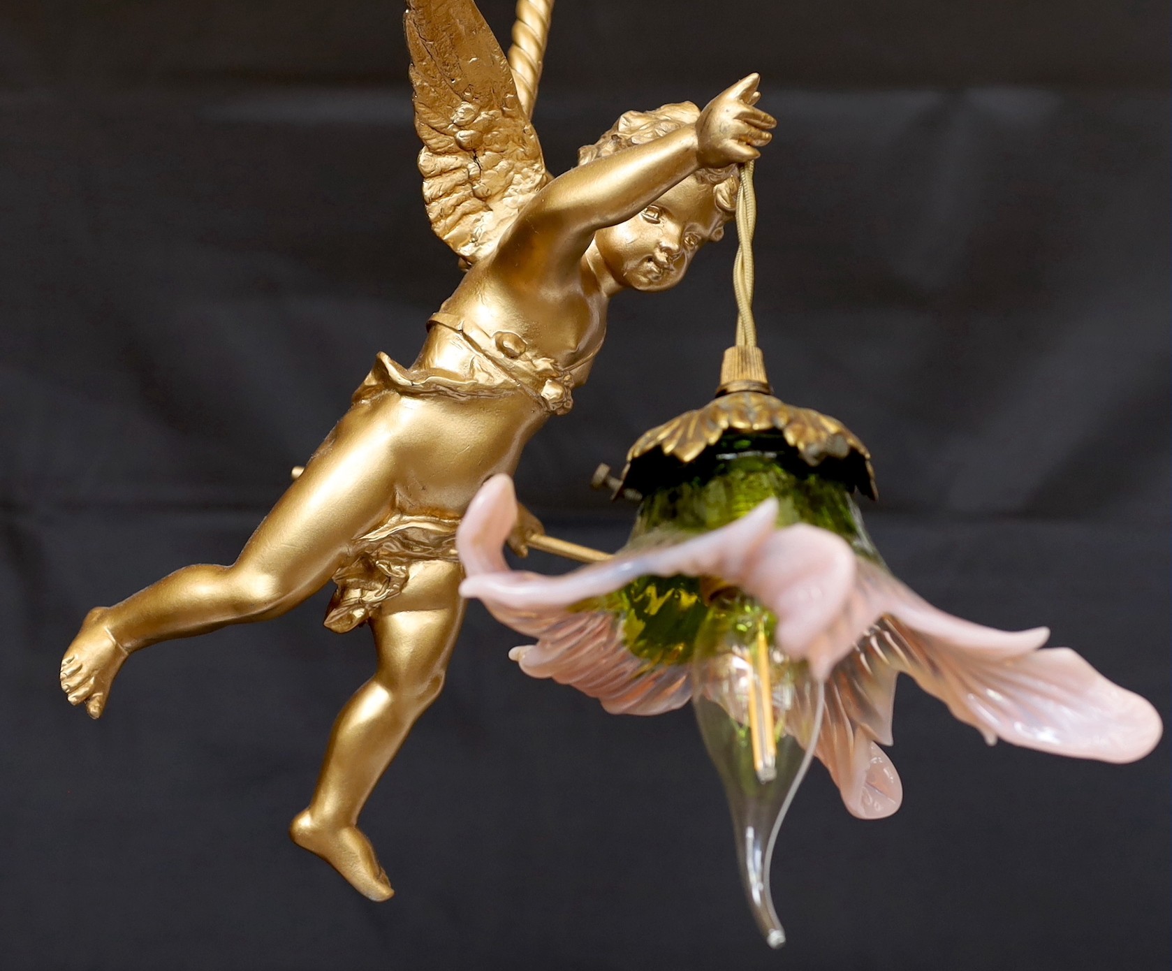 A 1920s English gold painted spelter Cupid light fitting with coloured glass shade, height 54cm. width 24cm